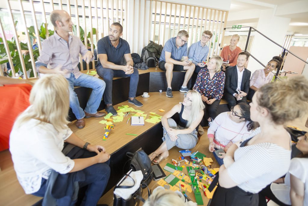 People discussing around a pile of legos